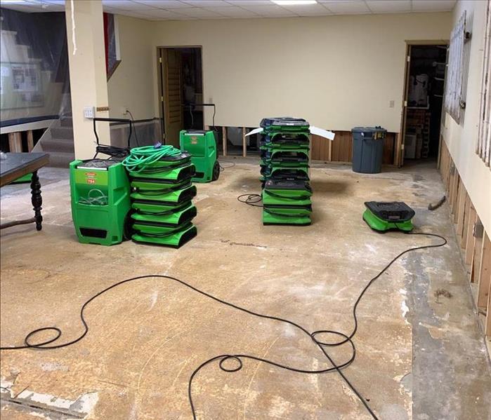 Air movers drying out a basement after a sewage backup caused damage.