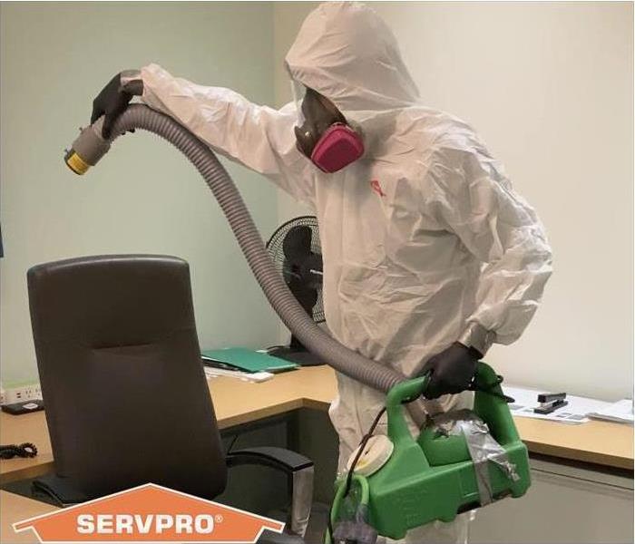 SERVPRO crew member in PPE cleaning a biohazard